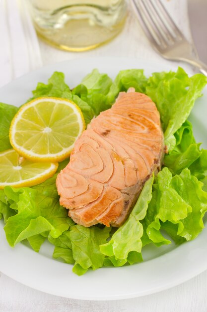 Saumon au citron sur laitue avec verre de vin