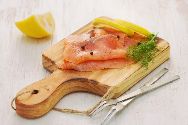 Saumon au citron et poivre noir sur planche de bois