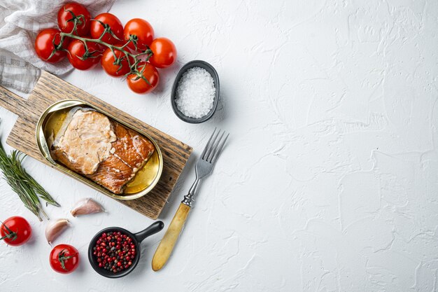 Saumon, conserves de poisson ensemble de poisson fumé en conserve, sur une planche à découper en bois, on white