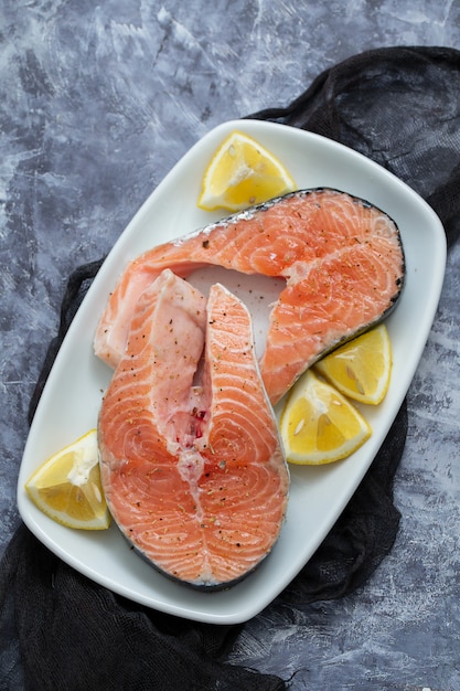 Saumon cru au citron sur un plat blanc sur fond de céramique