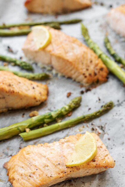 Photo le saumon délicieux au four, les asperges vertes et le citron dans la casserole.