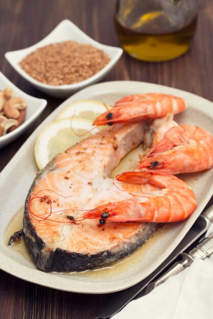 Saumon frit aux crevettes sur plat blanc sur une surface en bois