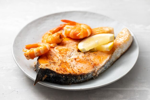 Saumon frit aux crevettes sur plat blanc