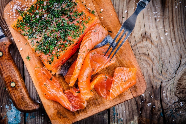 Saumon fumé maison à l'aneth sur une table en bois