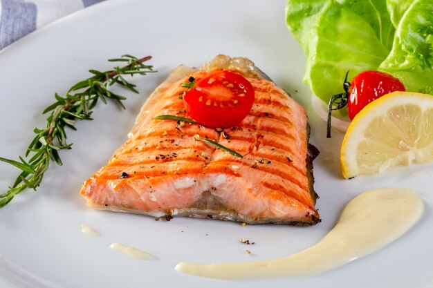 grillé Saumon avec crème sauce et persil sur une blanc plaque. Saumon filet  avec cuit patates. génératif ai 23594441 Photo de stock chez Vecteezy