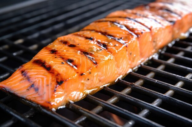 Saumon grillé avec glaçage au cidre de pomme en gros plan sur la grille du barbecue