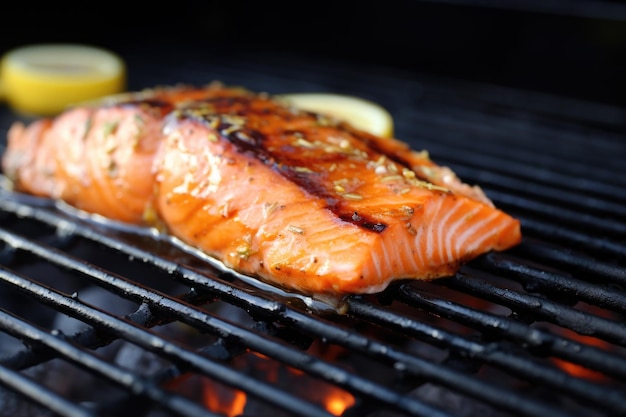 Saumon grillé avec glaçage au cidre de pomme en gros plan sur la grille du barbecue