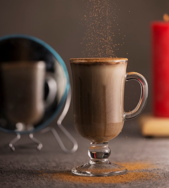 Saupoudrer de cannelle en poudre sur le chocolat chaud.