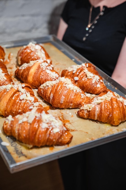 Saupoudrer les croissants finis sur une plaque à pâtisserie avec des flocons d'amandes