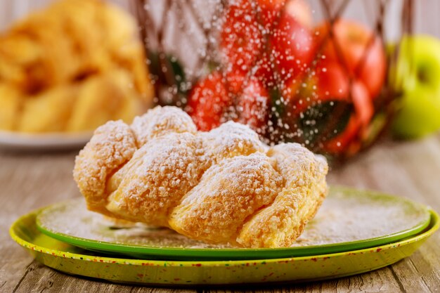 Saupoudrer de sucre en poudre sur du strudel aux pommes.