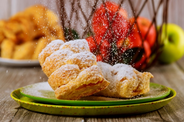 Saupoudrer de sucre en poudre sur un strudel aux pommes