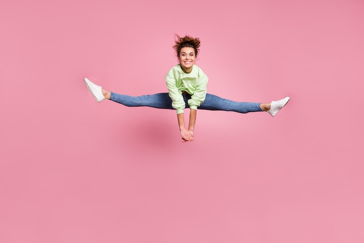 Photo saut de fille joyeuse athlétique de forme parfaite