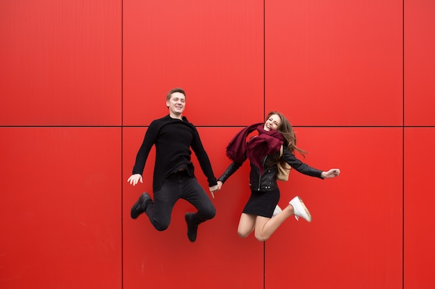 saut. Un homme et une femme sur fond rouge.