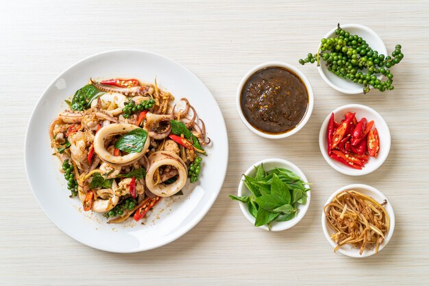 Sauté de basilic sacré avec poulpe ou calamars et herbes - style de cuisine asiatique