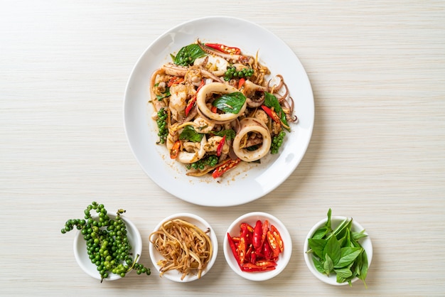 Sauté de basilic sacré avec poulpe ou calmar et herbes - style de cuisine asiatique