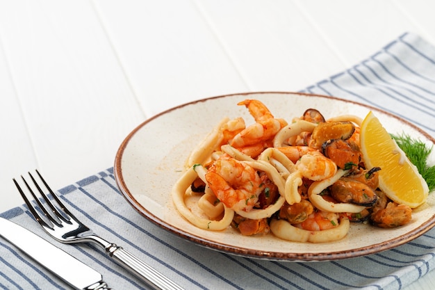 Sauté de fruits de mer avec sauce sur assiette avec serviette