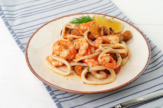 Sauté de fruits de mer avec sauce sur assiette avec serviette