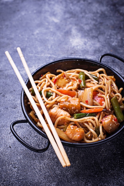 Sauté de nouilles avec du poulet, du tofu et des légumes.