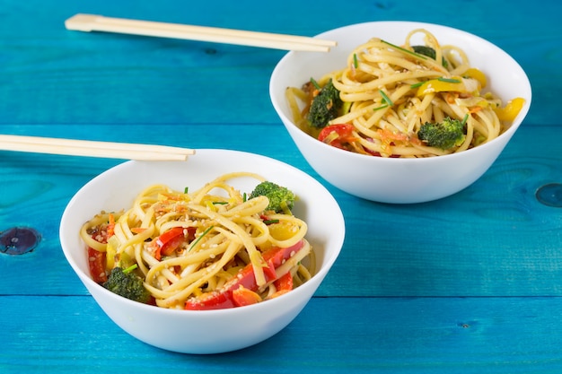 Sauté de nouilles japonaises avec légumes sur les bols