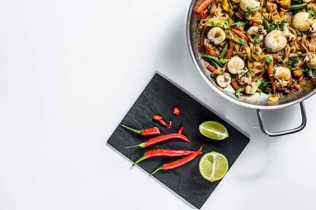 Sauté de nouilles Udon aux fruits de mer et légumes. Fond blanc. Vue de dessus. Espace copie