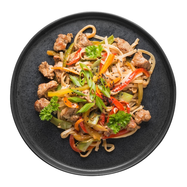 Sauté de nouilles udon avec du porc et des légumes colorés dans un plateau noir isolé sur blanc