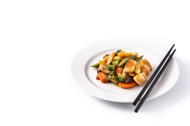 Photo sauté de poulet aux légumes sur plaque isolé sur fond blanc