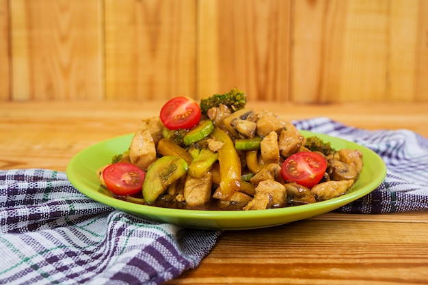 Sauté de poulet, courgettes et brocolis sur bois