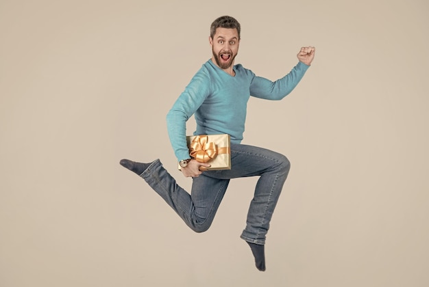 Sauter bel homme avec boîte cadeau homme d'affaires donnant un cadeau d'anniversaire énergique homme mal rasé