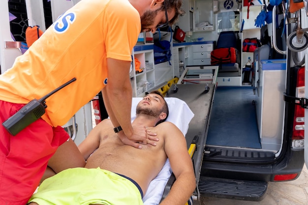 Sauveteur effectuant une réanimation cardio-respiratoire sur un homme au sommet d'une civière d'ambulance