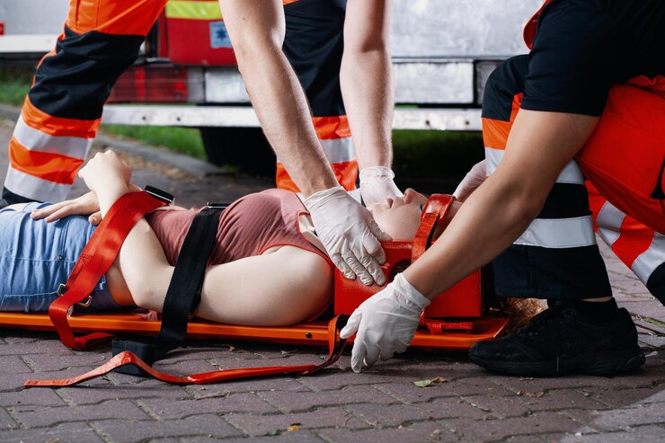 Photo sauveteur médical professionnel se penchant sur une victime d'un accident de voiture allongée sur une civière