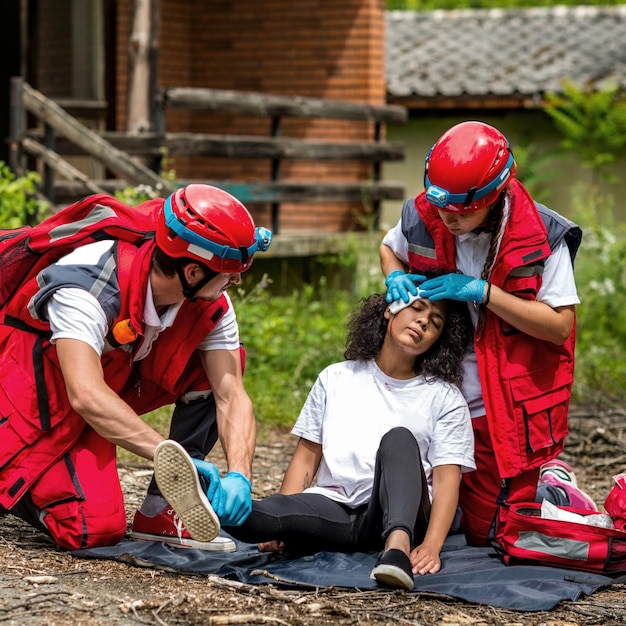 Photo des sauveteurs aident une femme blessée pendant une tornade.