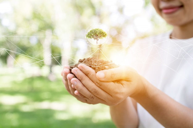 Sauvez le monde en plantant un arbre, une femme tenant un jeune arbre et une bonne énergie pour la connexion environnementale