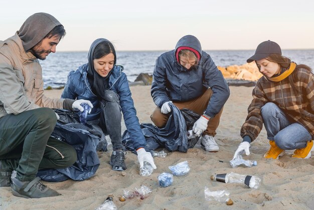 Sauvez la planète Groupe de volontaires ramassant des déchets sur la plage