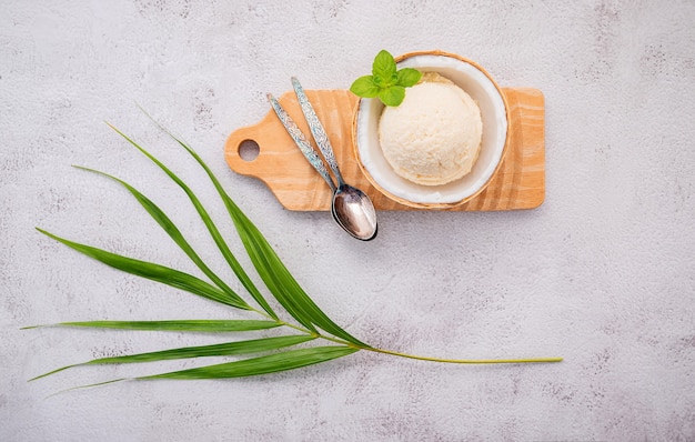 saveurs de crème glacée à la noix de coco dans la moitié de la configuration de noix de coco sur fond de pierre blanche.