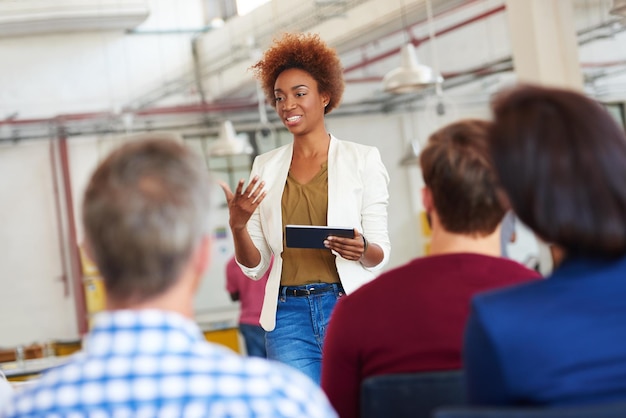 Savoir c'est pouvoir Une femme faisant une présentation à ses collègues à l'aide d'une tablette numérique