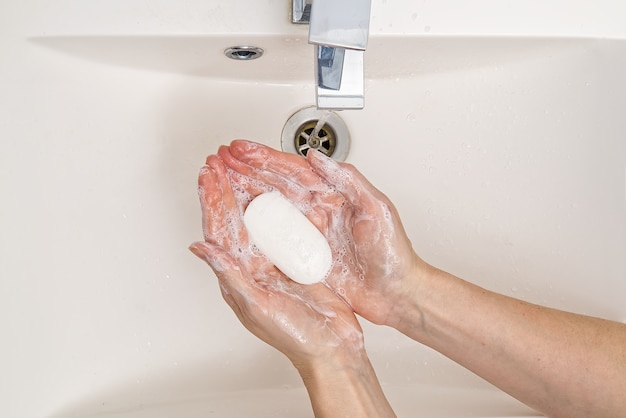 savon antibactérien dans les mains. mains savonneuses. Se laver les mains à l'eau et au savon.