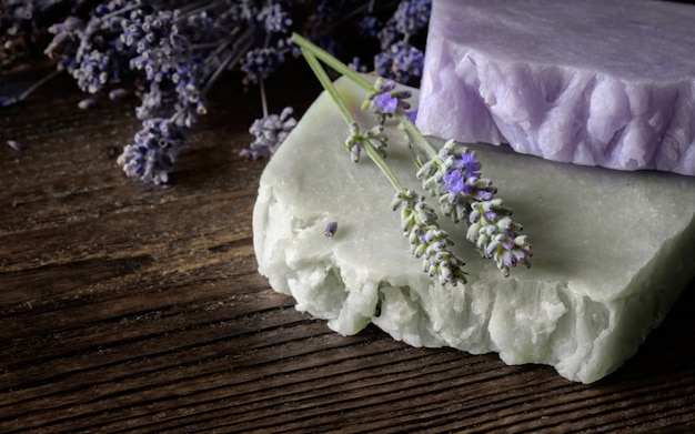 Savon artisanal aux fleurs de lavande sur planche de bois rustique.