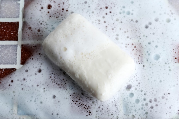 Savon avec bulle sur fond de carreaux de mosaïque