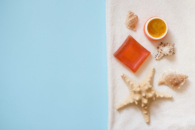 savon crème et orange avec coquillages et étoile de mer sur serviette blanche