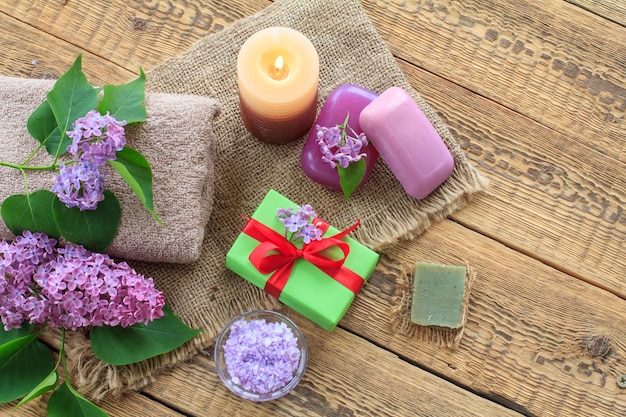 Savon éponge et sel de mer pour les procédures de salle de bain boîte cadeau bougie allumée et fleurs lilas