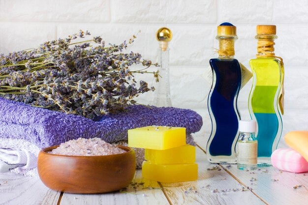 Savon à la lavande naturelle et sel de bain, huile française et serviettes sur un fond en bois blanc