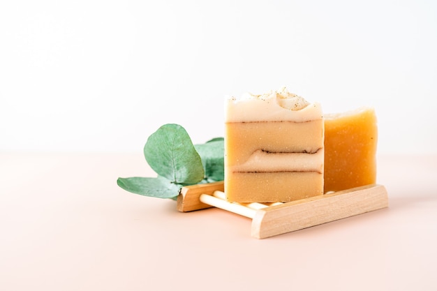 Savon maison à l'eucalyptus dans un porte-savon en bois sur fond de marbre blanc zéro déchet