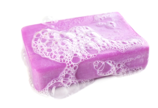 Savon avec mousse isolé sur blanc