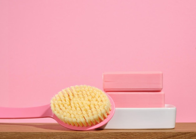 Savon rose sur un savon blanc et une brosse de douche avec des poils épais Copier l'espace pour le texte