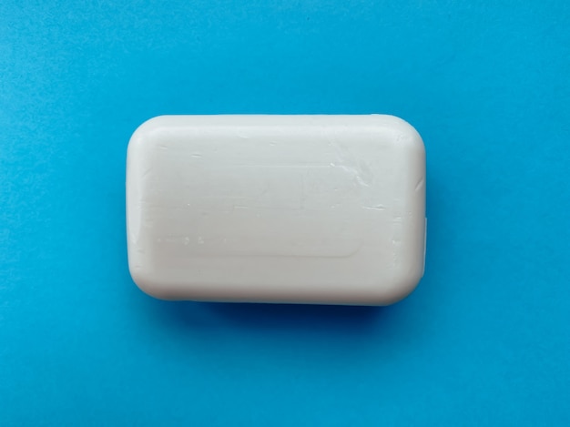 Savon solide pour les mains sur fond bleu. Hygiène et soins.