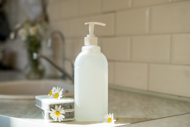 Savon à vaisselle écologique non toxique avec fleurs de camomille, assiettes blanches propres. photo de haute qualité