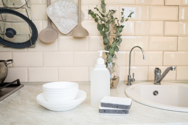 Savon à vaisselle écologique non toxique avec des fleurs de camomille pour nettoyer les assiettes blanches