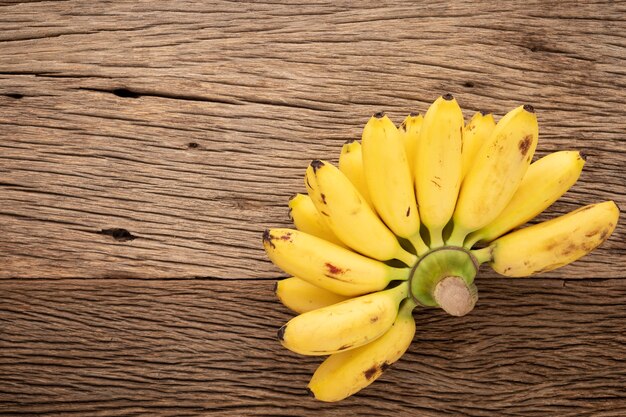 savoureuse banane mûre jaune fraîche sur fond de texture bois naturel rustique avec espace de copie pour le texte, vue de dessus