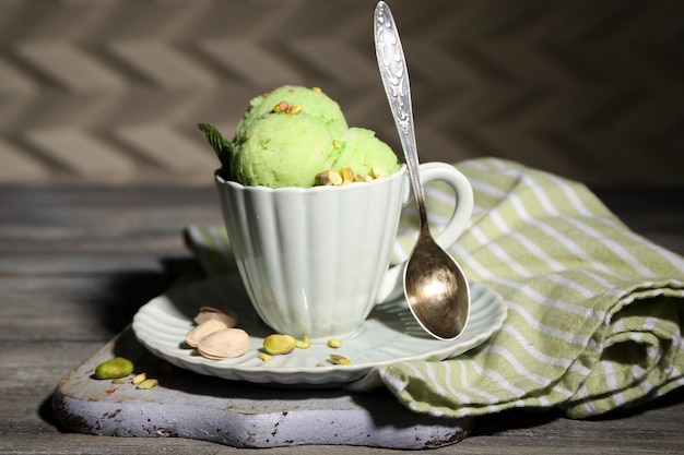 Savoureuse glace à la pistache dans une tasse sur une table en bois