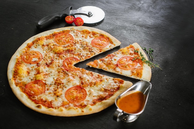 Savoureuse pizza au double fromage et tomates sur fond noir